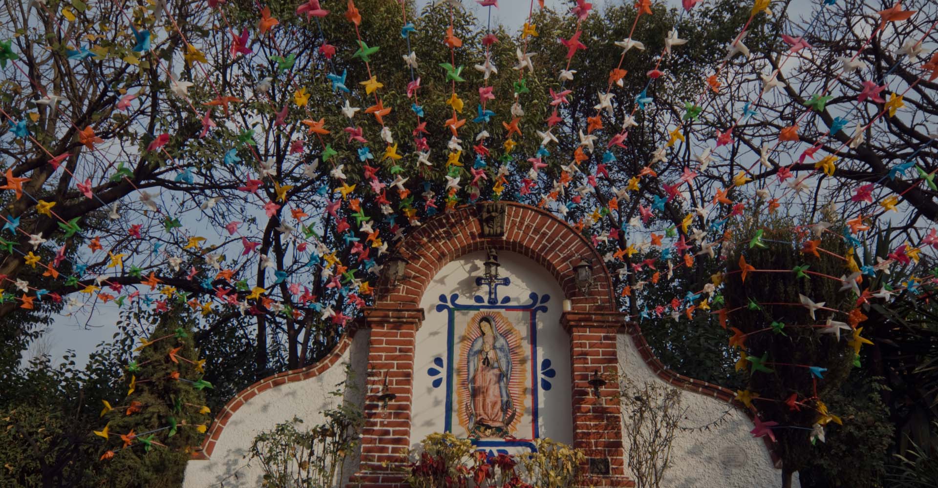 Our Lady of Guadalupe altar decorated with colorful pinwheels strung above