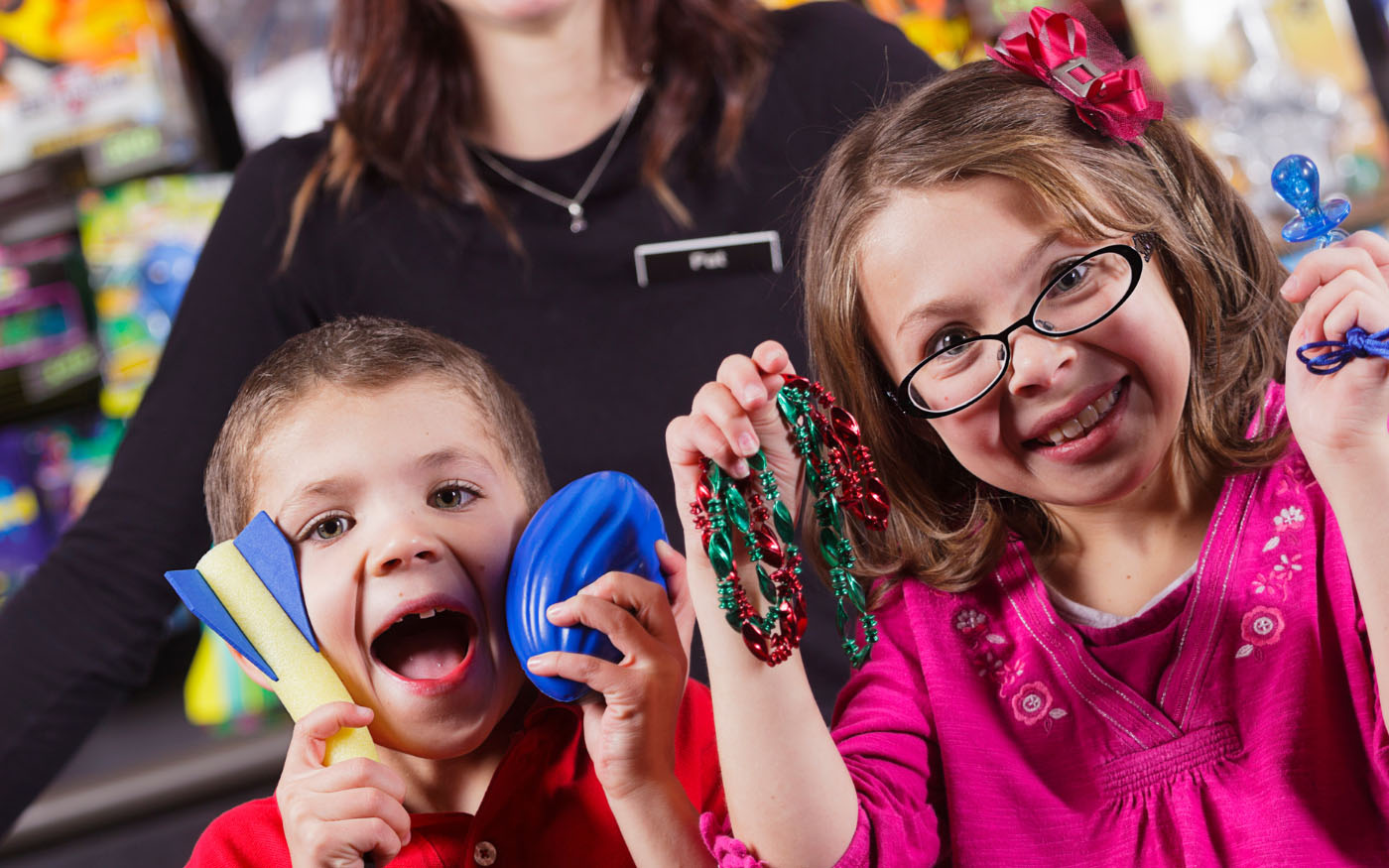 Smiling children holding up handfuls of prizes.