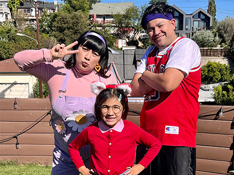 Mom, dad, and young daughter are posing proudly in their coordinated halloween costumes.