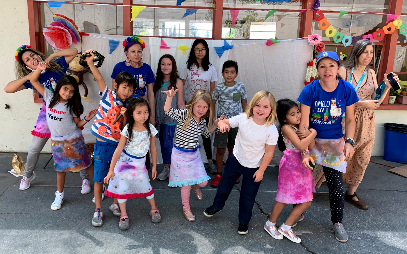 Young campers and their counselors making silly poses for an outdoor picture on a school patio